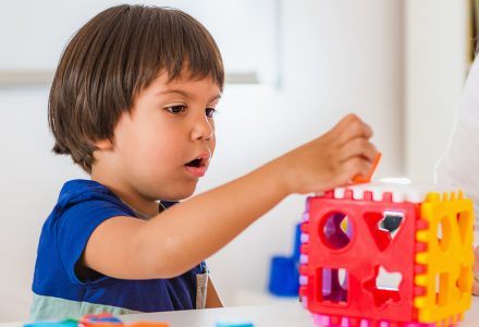 This is an image of a boy playing with building blocks of various colours.