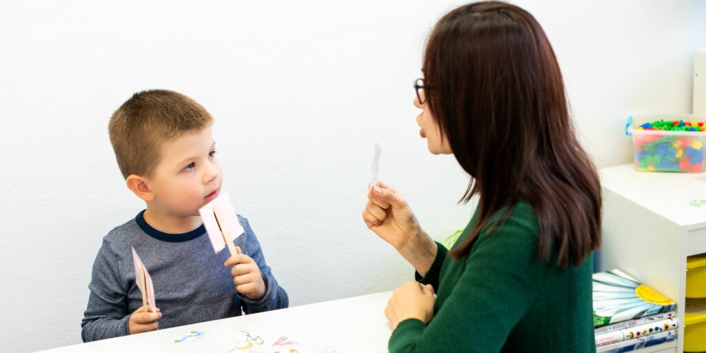 A therapist working on an child using speech and language therapy techniques