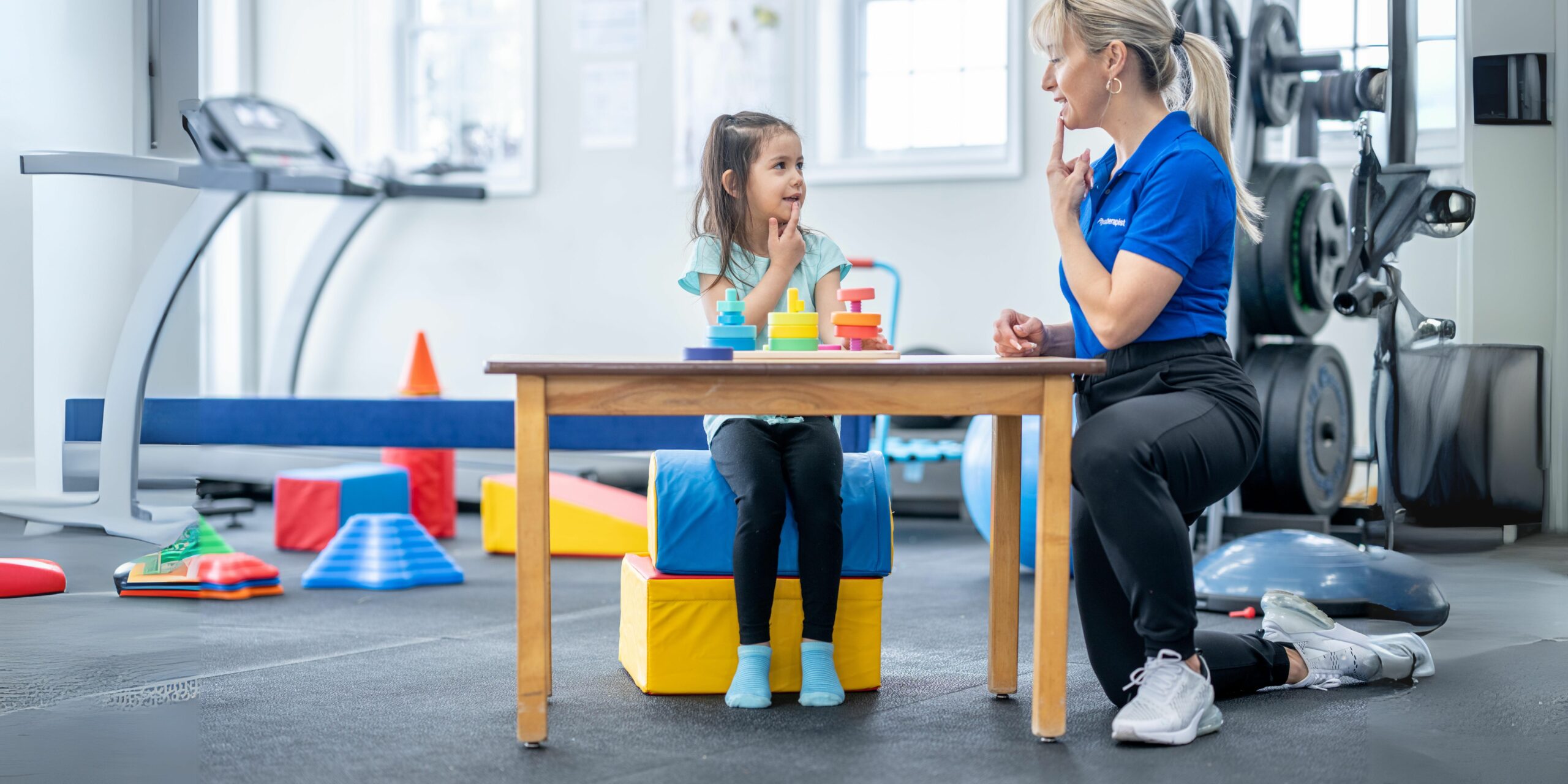This image depicts a speech therapist engaging with a child during a session designed to enhance speech and language skills for developmental purposes.